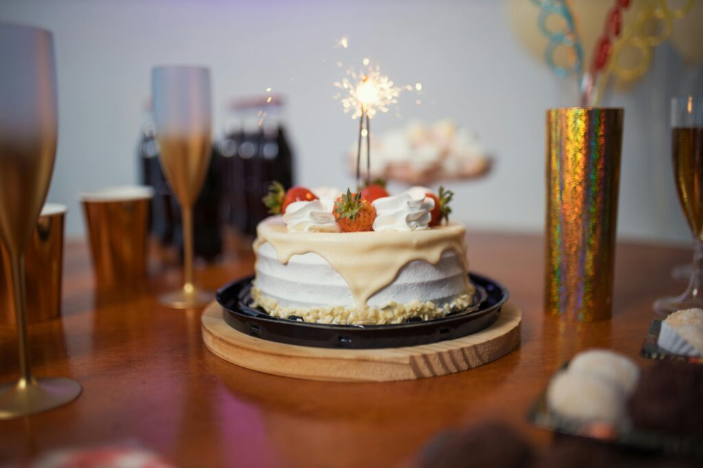 A festive birthday scene with a cake and sparkler on a decorated table, capturing the essence of celebration.